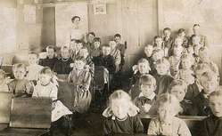 Foto antigua de las alumnas y las profesora dentro de clase.
