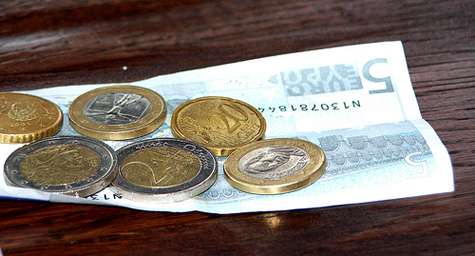 Un billete y varias monedas de euro.