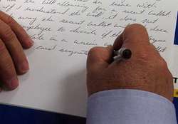 Una persona escribiendo una carta a mano.